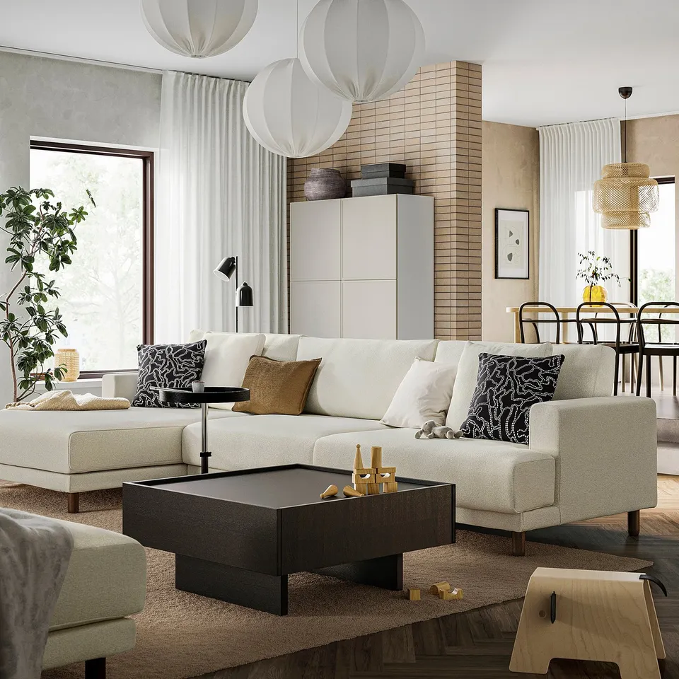 Modern living room with coffee table, sofa, and large window.