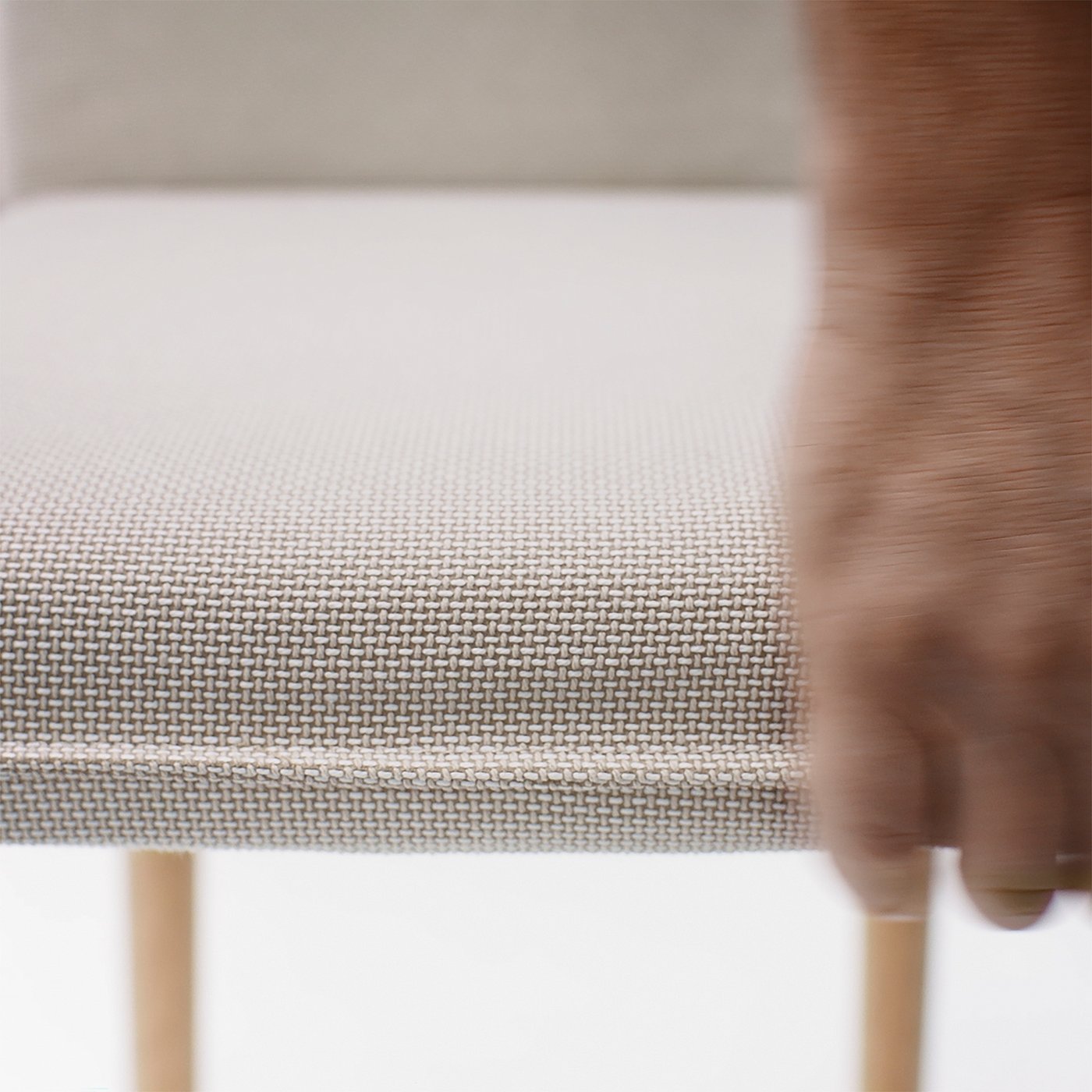 Close-up of woven fabric chair, showcasing intricate weave and plush texture, indicating high-quality comfort and durability.