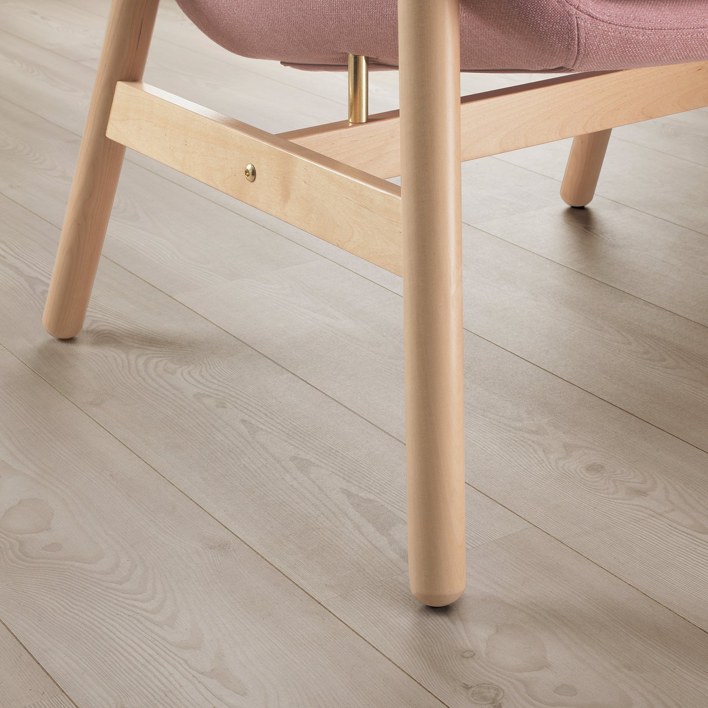Modern chair on light wood floor. Curved back, light wood legs, pinkish seat cushion. Elegant and supportive design.