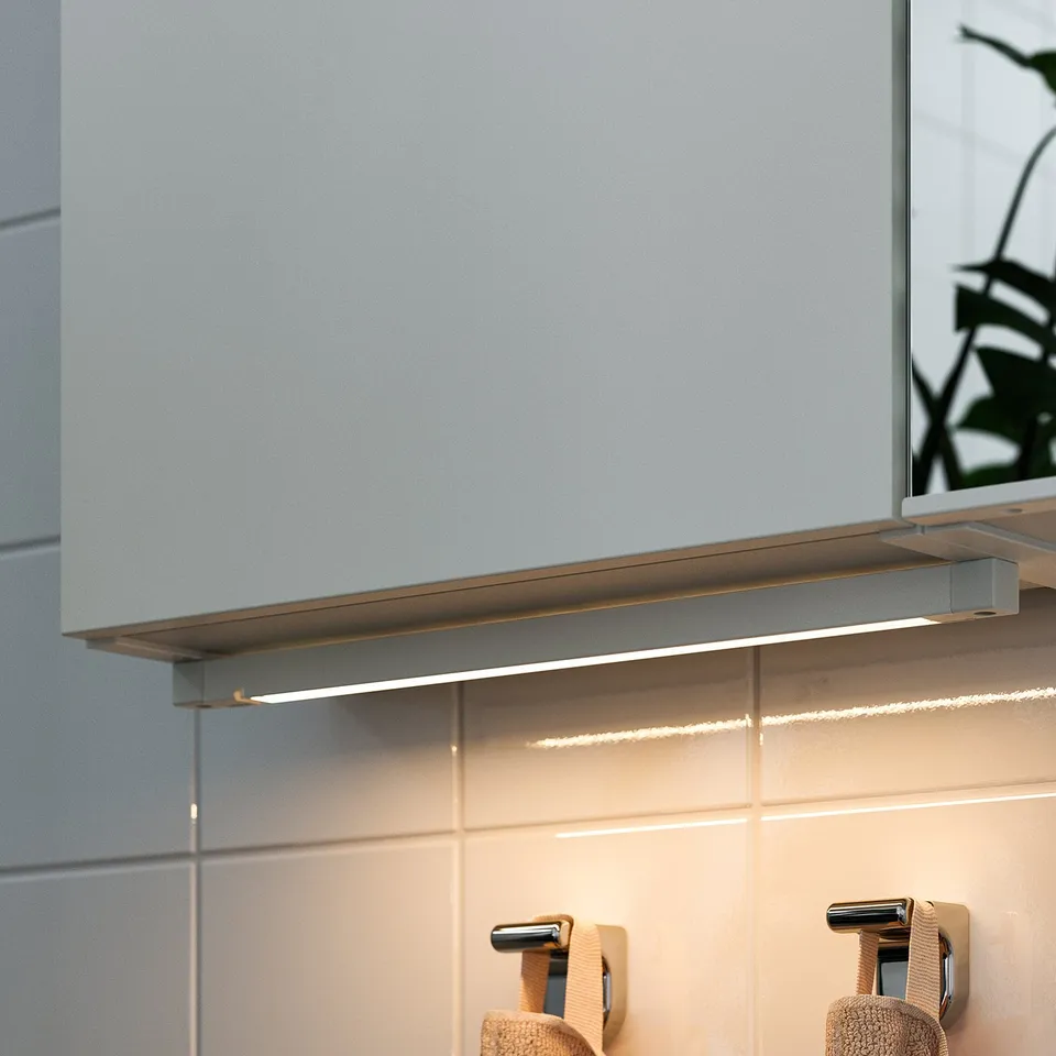 Modern bathroom with silver under-cabinet led lighting.