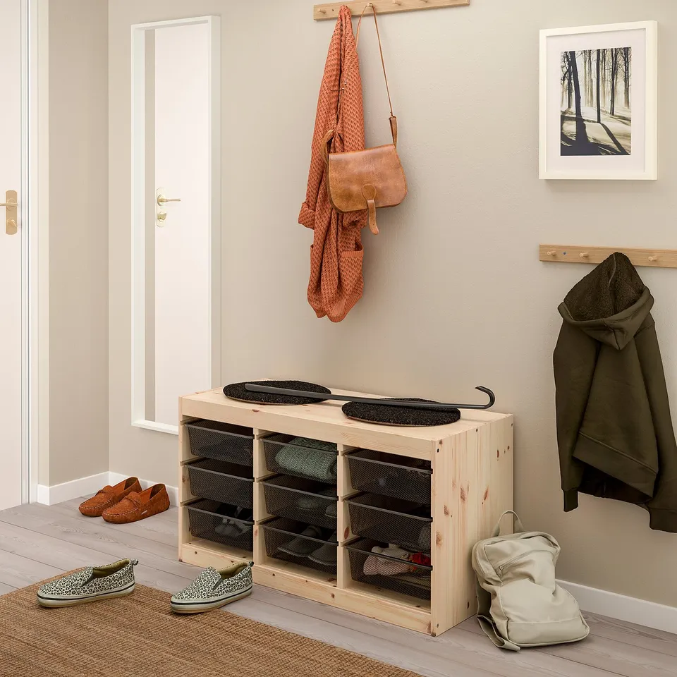 Entryway with TROFAST shoe storage, hanging jacket and bag, picture on wall.