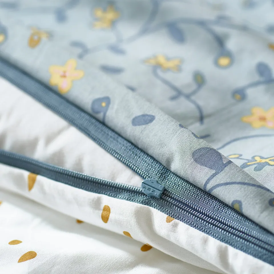 Blue zippered duvet cover with flower and dot patterns, featuring organic cotton.