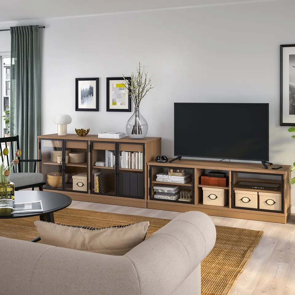Cosy living room with LANESUND tv stand and sideboard in wood finish, light beige sofa, large flat screen tv, decorative vases, and framed wall art.