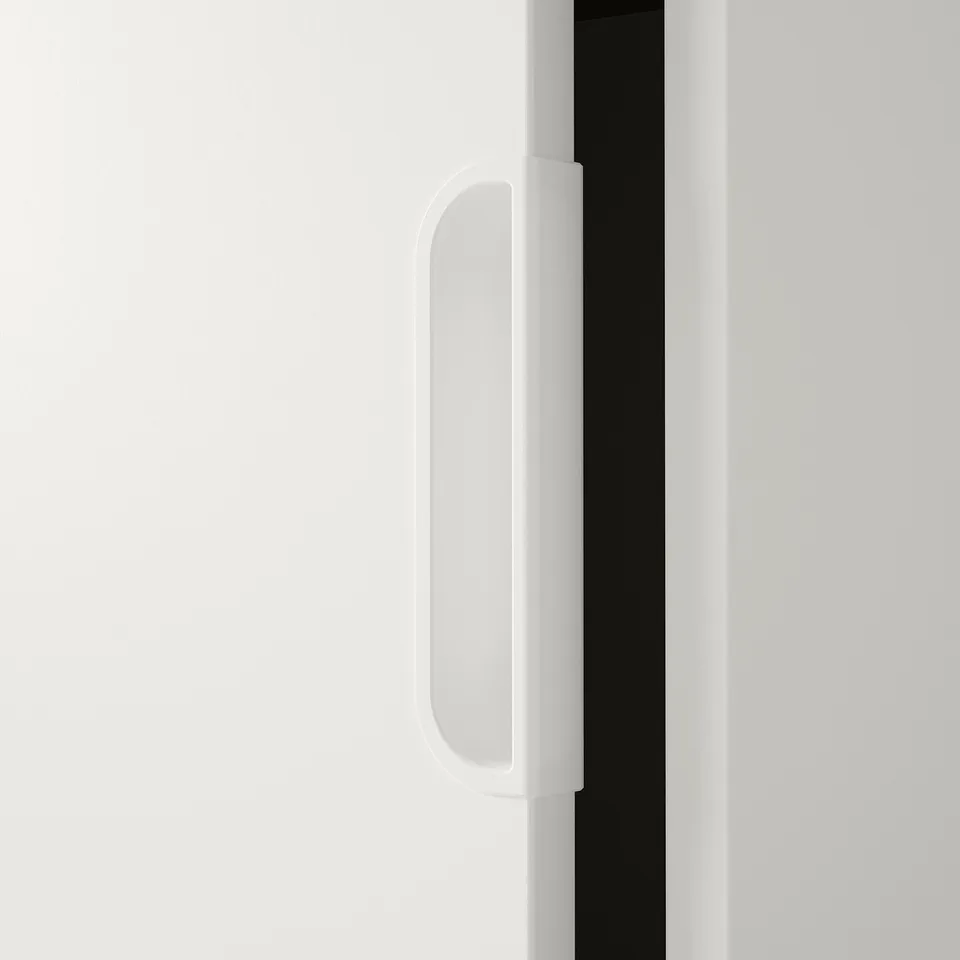 Close-up of sleek, smooth white door handle on modern cabinet, displaying sleek design and quality finish.