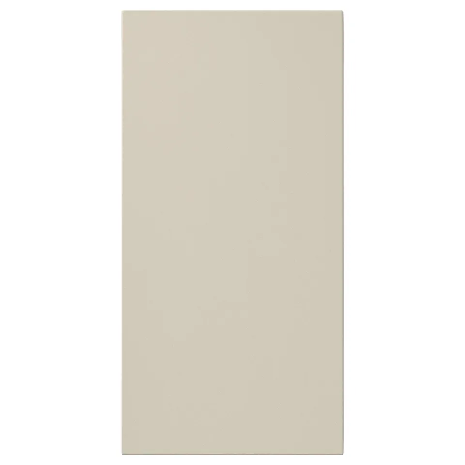 A beige HAVSTORP kitchen cabinet door. The smooth, rectangular door has clean lines and a modern look. Its made of acrylic-painted fibreboard.